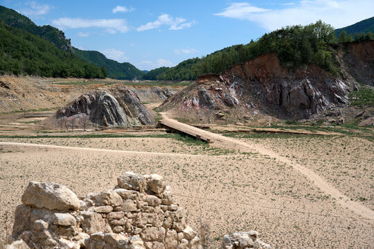 Drought - cracked dry mud bridge roadway and ruin