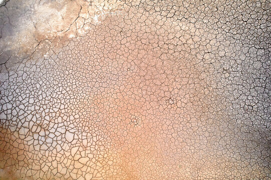 Dry mud cracked by drought forms abstract aerial shapes