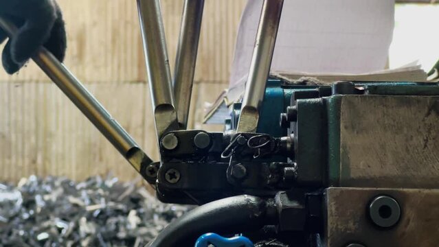 Hand of machine operator is moving the machine lever.