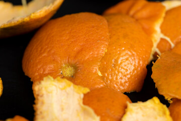 a large number of orange citrus fruits on a black slate surface - 751250970