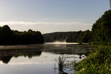 a wide river at dawn in the autumn season