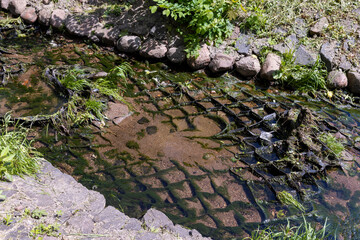 water flowing in a small narrow stream in summer