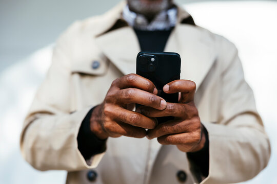 Cropped view of man using smartphone