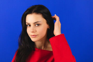 Lovely coquettish brunette woman, winking playfully, flirting, throws her hair. Woman fix her hair....