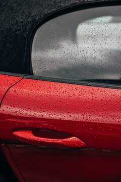 Modern red cabrio car with rain on the car body