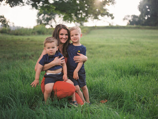 smiling mother with her boys outdoors in summer