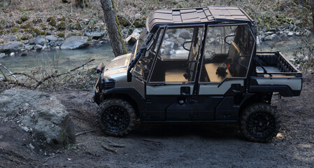 ATV awd quadbike with roof and door motorcycle pov view near lake or river  coast with nature landscape. forest background. Offroad travel adventure trip expedition. Extreme sport recreation quad bike