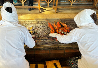 海女小屋で新鮮な伊勢海老や貝を炭火焼きにする海女さん 三重県日本