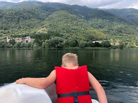  kid on a lake swimming on pedal boat 