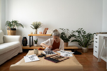 Retired woman painting sumie kanji 