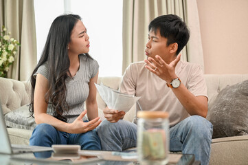 Unhappy Asian spouses are arguing about unexpected high household bills and credit card invoices.