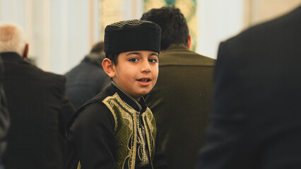 Muslim young boy wear a beauty Muslim prayer cap at Mosque.
