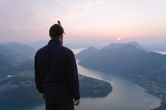 Fototapeta Male Tourist observing mountain lake at sunset