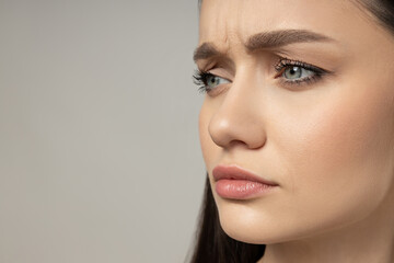 Attractive young girl on a gray background. Botox concept