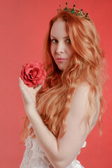 Portrait of a red-haired princess with an artificial flower in her hand - 751277185