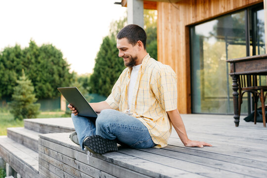 A man uses a laptop outdoors