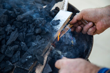 Close-up of a caucasian man burning coals in a barbecue