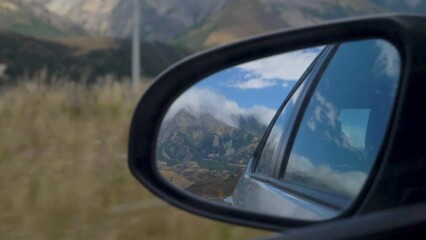 Slow Motion shot of a mountain in a car wing mirror - Arthur's Pass, New Zealand
