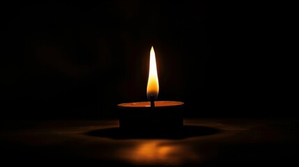 single flame burns brightly, reflecting its light on the water’s surface