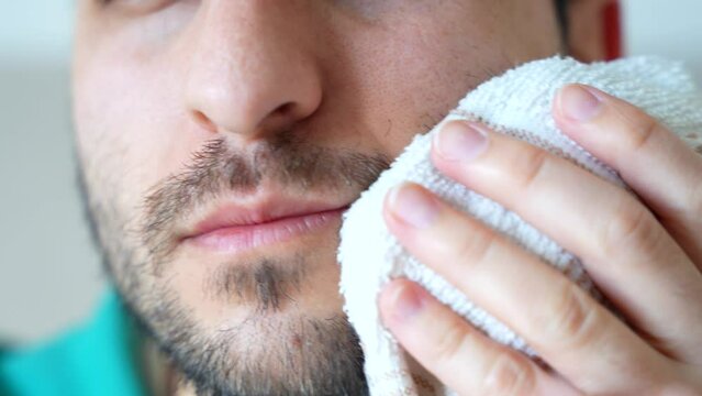 Face of man in pain applying ice after wisdom tooth extraction, 4K