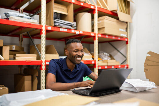 Worker Using Laptop At Packaging Department