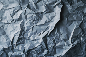 A piece of paper crumpled in half, creating a distinct crease in the center