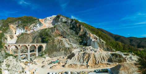 A panoramic view of a marble quarry in Tuscany with the old railway bridge.