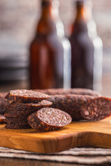 Sliced salami sausage on cutting board on kitchen table.
