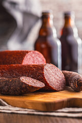 Sliced salami sausage on cutting board on kitchen table.