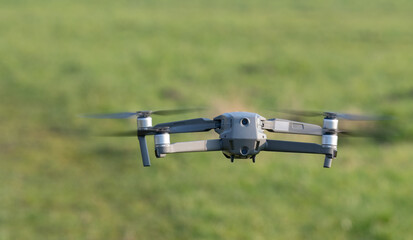 Drohne fliegt über einer grünen Wiese