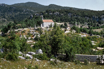 Fototapeta na wymiar Church and cemetry at Niksic in the eighties. Montenegro. Former Joegoeslavia in the eighties