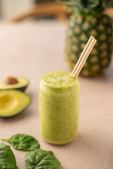 Avocado and spinach smoothie on a coffee shop table. Vegan smoothie, healthy drink. Side view.
