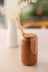 Chocolate smoothie on a coffee shop table. Vegan smoothie, healthy drink. Side view.