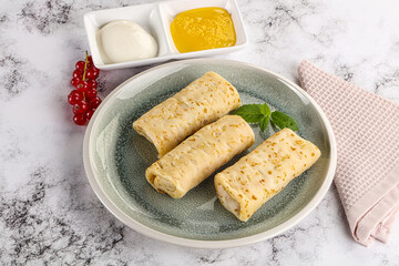Homemade stuffed pancakes with honey and cream sour