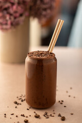 Chocolate smoothie on a coffee shop table. Vegan smoothie, healthy drink. Side view.