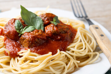 Spaghetti with meatballs on wooden table. Close up