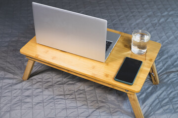 Laptop, smartphone and glass of water on the wooden Cooling pad for laptop. Notebook Cooler for Computer, USB Fan.