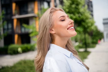 Foto op Canvas Portrait of dreamy attractive cheerful blonde hair smiling girlfriend breathing fresh air when relocated to new city with green parks © deagreez