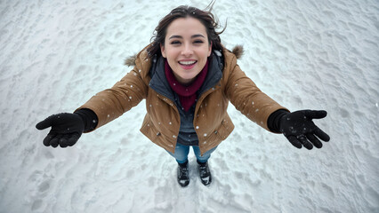 Snow falling over a beautiful woman looking up the sky