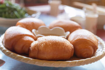 Golden fried Mantou or Chinese fried bun in a basket with sweet condensed milk on the table.