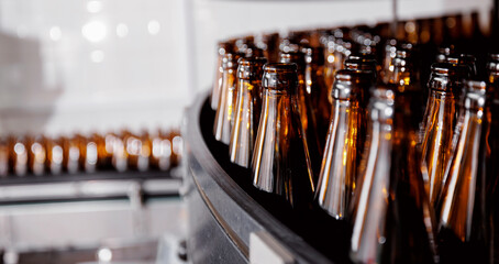 Brown glass beer drink alcohol bottles, brewery conveyor, modern industrial food production line...