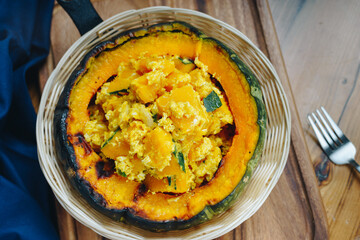 A bowl of food with a pumpkin in the center