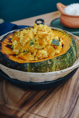 A bowl of food with a green squash in the center
