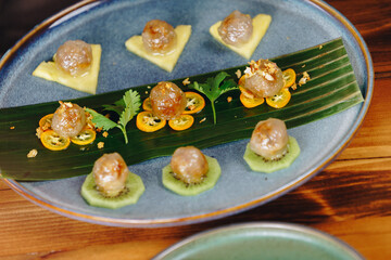 A plate of food with a variety of fruits and vegetables, including kiwi, oranges