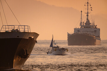 朝日照らす関門航路で近づく漁船と貨物船20240212-2