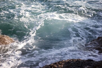 Sea waves spattering on the rocky shore