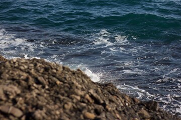 Sea waves spattering on the rocky shore