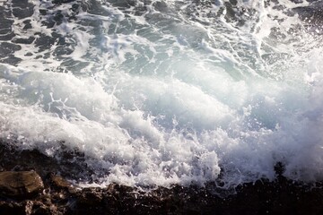 Sea waves spattering on the rocky shore