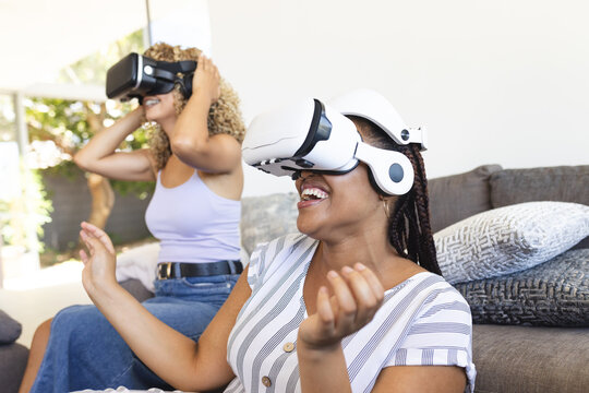 Biracial women enjoy virtual reality at home