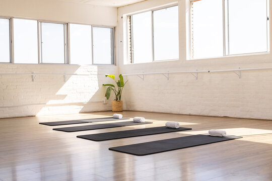 A serene yoga studio awaits practitioners, bathed in natural light, with copy space